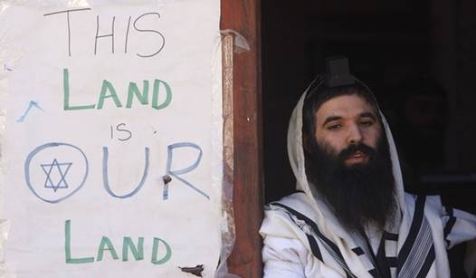 A Jewish settler prays at the entrance to a disputed house in Hebron on December 2, 2008. At least 13 Palestinians were wounded overnight as more than 1,000 ultra-nationalist Israelis hurled rocks at residents, homes and police jeeps during protests against plans by Israeli authorities to dislodge them from the disputed house  in the flashpoint West Bank city, according to witnesses. The controversial house was occupied by dozens of hardline Jewish settlers in March 2007 and they have remained in the building despite a November 16 court order for them to move out. The settlers say they bought the house from a Palestinian, who denies that a deal was ever completed. From Getty Images by AFP/Getty Images.