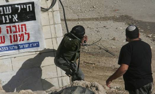An Israeli border policeman prepares to launch a stunt granade during riots in which dozens of Israeli settlers pelted Paletinian homes near a disputed house in the flashpoint West Bank city of Hebron December 2, 2008. At least 13 Palestinians were wounded overnight as more than 1,000 ultra-nationalist Israelis hurled rocks at residents, homes and police jeeps in the flashpoint West Bank city of Hebron. The rioting broke out as rumours spread that security forces were set to evict 100 Jewish settlers from a house the Israeli high court has ordered evacuated. The Israeli High Court on November 16 ordered the settlers to leave the Hebron house in which they have lived since March 2007, but security forces have not enforced the order to date. From Getty Images by AFP/Getty Images.