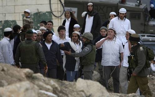 Israeli soldiers stop Jewish settlers from throwing stones at Palestinians near the disputed house in the West Bank city of Hebron November 29, 2008. Jewish settlers and Palestinians hurled stones at each other in the West Bank city of Hebron on Saturday before Israeli soldiers separated the two sides, the army and Palestinian witnesses said. From Reuters Pictures by REUTERS.