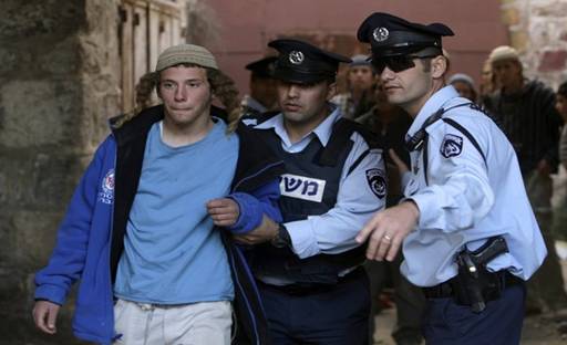 Israeli police officers walk with a Jewish settler after removing him from a previously evacuated house in the West Bank city of Hebron December 3, 2008. According to local media reports, dozens of Jewish settlers were removed by Israeli police on Wednesday from a house that had been evicted in 2006 following a High court order. From Reuters Pictures by REUTERS.